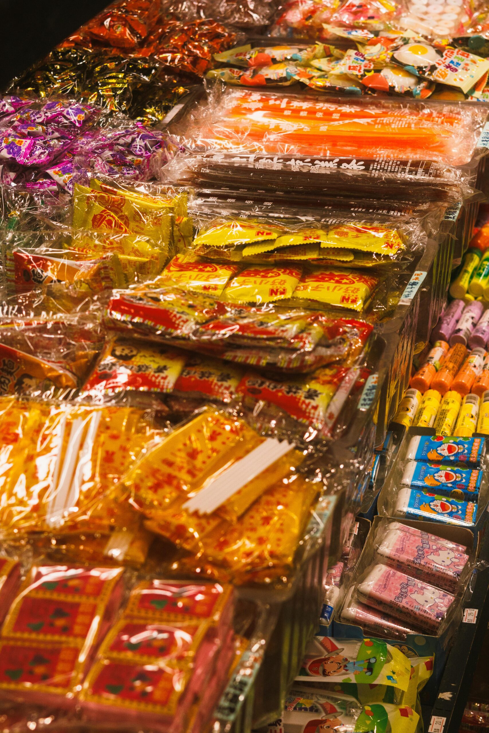 Vibrant assortment of packaged Asian snacks on display in a market.