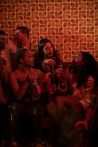 A diverse group of friends enjoying a festive indoor party with drinks and laughter.